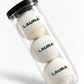 Mockup of three white tennis balls personalised with LAURA in green, in a clear tube with a black lid.