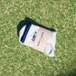 White and navy womens tennis socks by Forty-Love folded on a tennis court, designed for comfort and on-court performance.