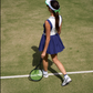 Back view of a women’s tennis dress on court, showing pleated skirt movement and streamlined athletic cut.