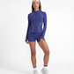 Studio lifestyle image of a navy women’s tennis jacket styled as a complete long sleeve tennis outfit.