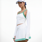 Model wearing a white and green women’s tennis outfit with pleated skort, designed for performance and modern style.