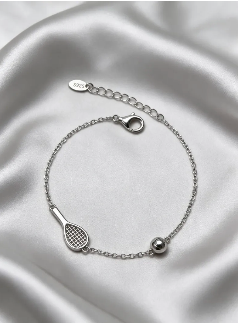 Sleek tennis bracelet with silver racquet and ball detail on a white background