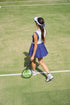 White and navy womens tennis visor by Forty-Love worn on court, lightweight tennis visor designed for sun protection and performance.